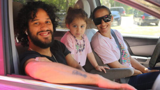 Happy family in car receiving SnackPacks